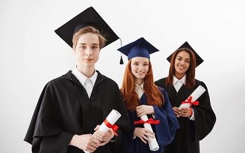 Three happy international university graduates smiling rejoicing holding diplomas over white background. Future lawyers or engineers.